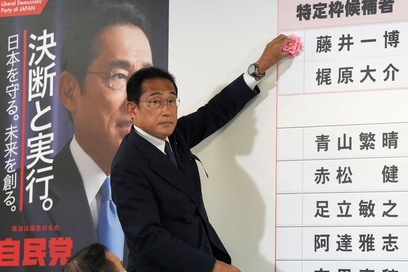 &copy; Reuters. Fumio Kishida, primer ministro de Japón y presidente del Partido Liberal Democrático (PLD), coloca una rosa de papel roja sobre el nombre de un candidato del PLD, para indicar una victoria en las elecciones a la cámara alta, en la sede del partido en T