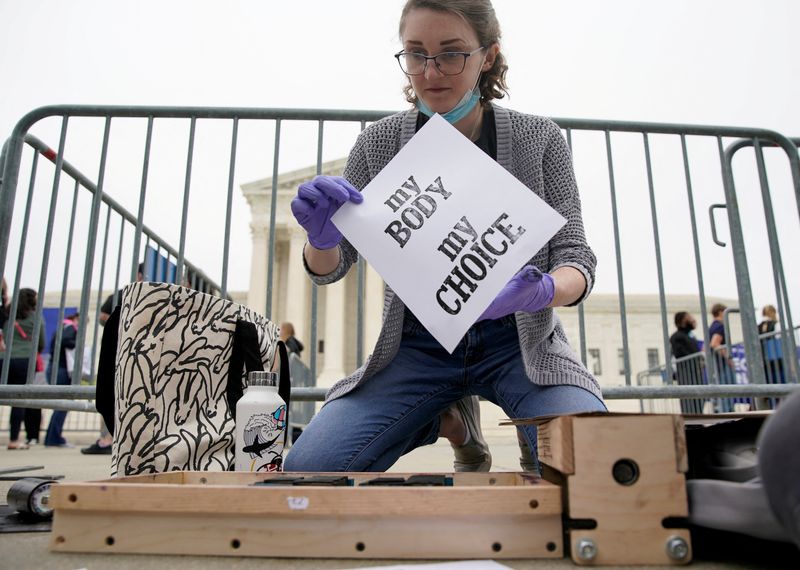 &copy; Reuters. FILE PHOTO: Nat McGartland, 27, of College Park, Maryland, makes signs on a letterpress during a protest outside the U.S. Supreme Court after the leak of a draft majority opinion written by Justice Samuel Alito preparing for a majority of the court to ove