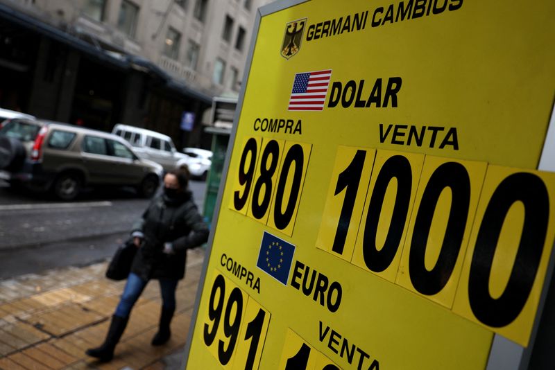 &copy; Reuters. A woman passes a sign showing the exchange rate for the U.S. dollar and other currencies in Santiago, Chile July 11, 2022. REUTERS/Ivan Alvarado