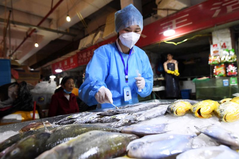 &copy; Reuters. 　７月１２日、中国国家衛生健康委員会は、地方政府が輸入品に実施している新型コロナウイルス検査について、一部が不要になると発表した。写真は万東市場で冷凍された魚からコロナ検