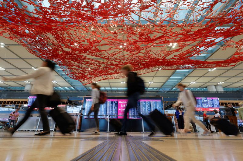 &copy; Reuters. FOTO DE ARCHIVO. Pasajeros caminan en el aeropuerto de Berlín-Brandeburgo (BER), en Schönefeld, cerca de Berlín, Alemania. 7 de julio de 2022. REUTERS/Michele Tantussi