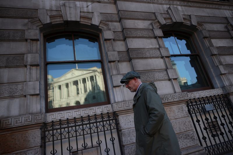 &copy; Reuters. FILE PHOTO: A man walks past a window reflecting the Bank of England, in London, Britain, December 17, 2020. REUTERS/Hannah McKay/