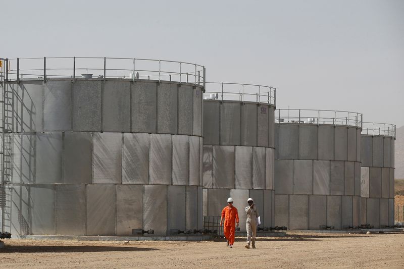 &copy; Reuters. FILE PHOTO: Workers walk past storage tanks at Tullow Oil's Ngamia 8 drilling site in Lokichar, Turkana County, Kenya, February 8, 2018. REUTERS/Baz Ratner