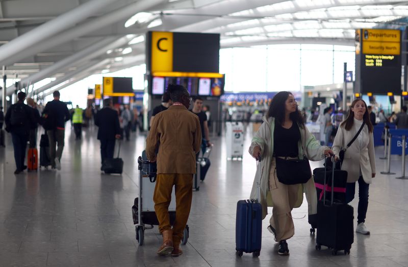 © Reuters. FILE PHOTO: Passengers walk with their luggage through Heathrow Terminal 5 airport in London, Britain, June 1, 2022. REUTERS/Hannah McKay