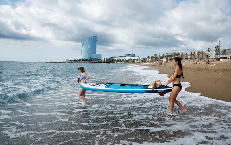 &copy; Reuters. Voluntarios reman una tabla con una red de arrastre en la playa de Sant Sebastia durante un proyecto de investigación "Surfing for Science" de la Universidad de Barcelona para evaluar la contaminación por microplásticos en el litoral, en el barrio de l