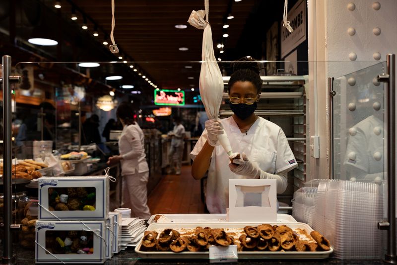 © Reuters. FILE PHOTO: A worker fills a cannoli at a bakery at Reading Terminal Market after the inflation rate hit a 40-year high in January, in Philadelphia, Pennsylvania, U.S. February 19, 2022. REUTERS/Hannah Beier