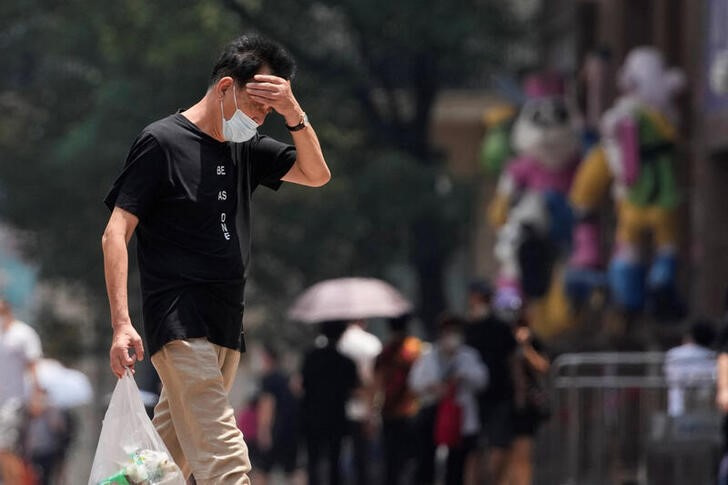&copy; Reuters. Un hombre con mascarilla durante un día de ola de calor en Shanghái, China, el 13 de julio de 2022. REUTERS/Aly Song