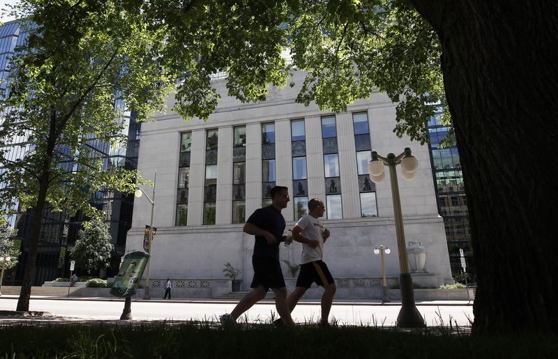 © Reuters. FILE PHOTO - Joggers run past the Bank of Canada building in Ottawa June 5, 2012.       REUTERS/Chris Wattie    