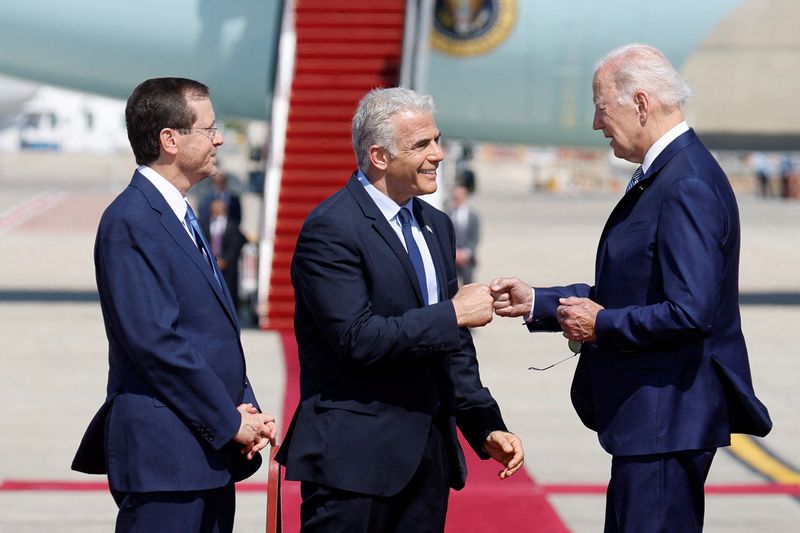 © Reuters. Israeli President Isaac Herzog looks on as Prime Minister Yair Lapid bumps fists with U.S. President Joe Biden during a welcoming ceremony at Ben Gurion International Airport in Lod, near Tel Aviv, Israel, July 13, 2022. REUTERS/Amir Cohen    