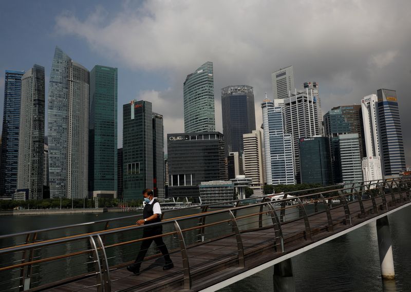 &copy; Reuters. FILE PHOTO: A man passes the city skyline during the coronavirus disease (COVID-19) outbreak, in Singapore, September 29, 2021. REUTERS/Edgar Su