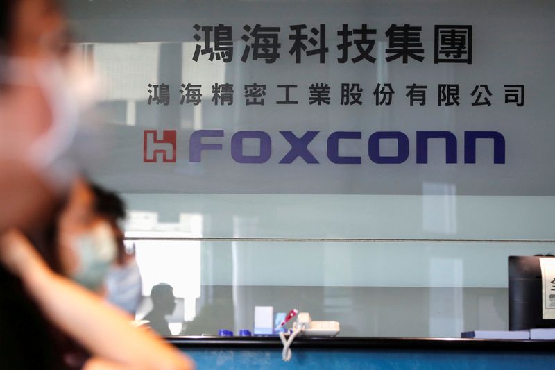 &copy; Reuters. FILE PHOTO: People wear masks to protect themselves from coronavirus disease (COVID-19), while listening to the annual general meeting at the lobby of Foxconn's office in Taipei, Taiwan, June 23, 2020. REUTERS/Ann Wang