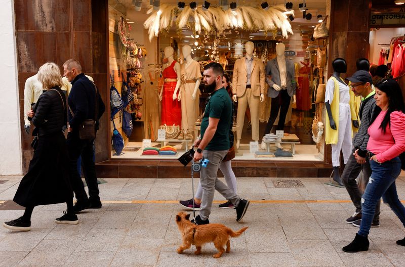 &copy; Reuters. FOTO DE ARCHIVO: Gente pasando por delante de una tienda de ropa en Ronda, al sur de España, 27 de abril de 2022. REUTERS/Jon Nazca