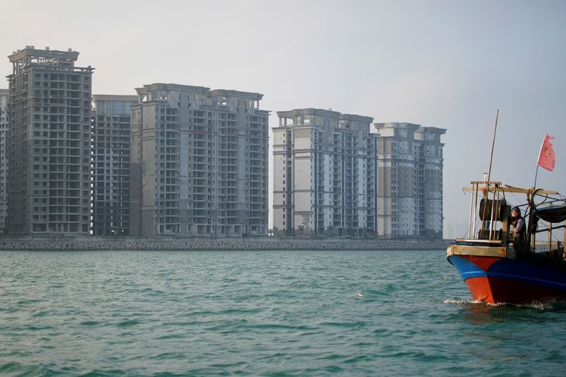 &copy; Reuters. FILE PHOTO: A vessel travels past some of the 39 buildings developed by China Evergrande Group that authorities have issued demolition order on, on the man-made Ocean Flower Island in Danzhou, Hainan province, China January 7, 2022. REUTERS/Aly Song