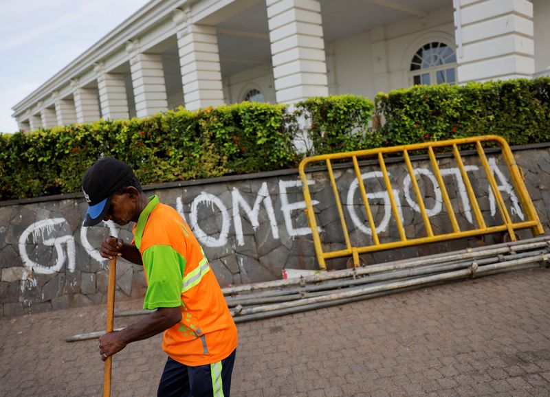 © Reuters. A man sweeps the road to President's official residence after parliament Speaker Mahinda Yapa Abeywardena officially announced the resignation of president Gotabaya Rajapaksa who fled to Singapore amid Sri Lanka's economic crisis, in Colombo, Sri Lanka, July 15, 2022. REUTERS/Dinuka Liyanawatte