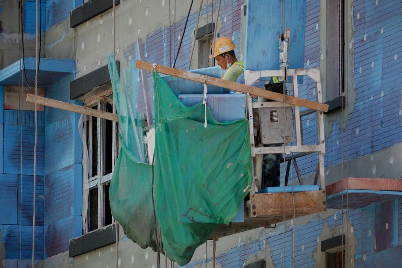 © Reuters. A man works at a construction site of apartment buildings in Beijing, China, July 15, 2022. REUTERS/Thomas Peter