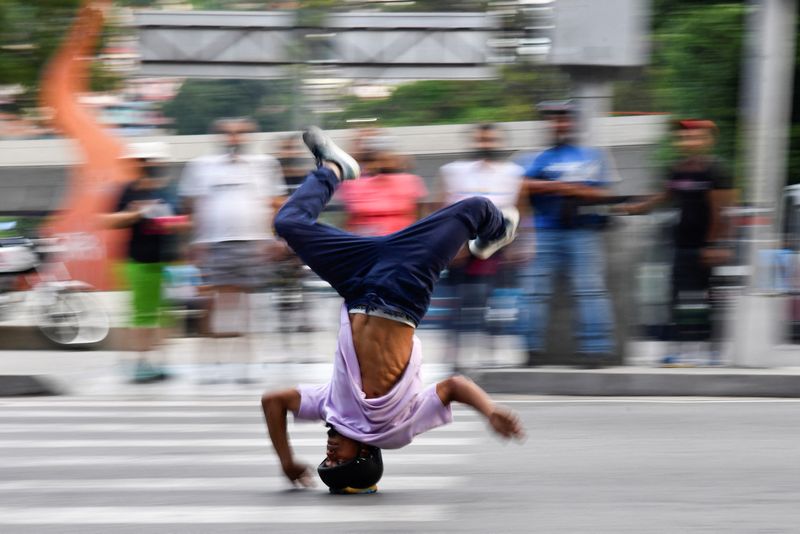 &copy; Reuters. El atleta profesional de breakdance venezolano Kenyer Méndez, de 27 años, se desliza por una calle de cabeza en un semáforo, en Caracas
 Jun 22, 2022. REUTERS/Gaby Oraa 