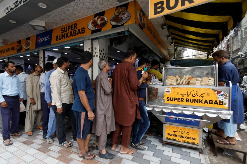 &copy; Reuters. People wait for their turn to buy low-priced bun-kabab from a shop in Karachi, Pakistan June 10, 2022. REUTERS/Akhtar Soomro
