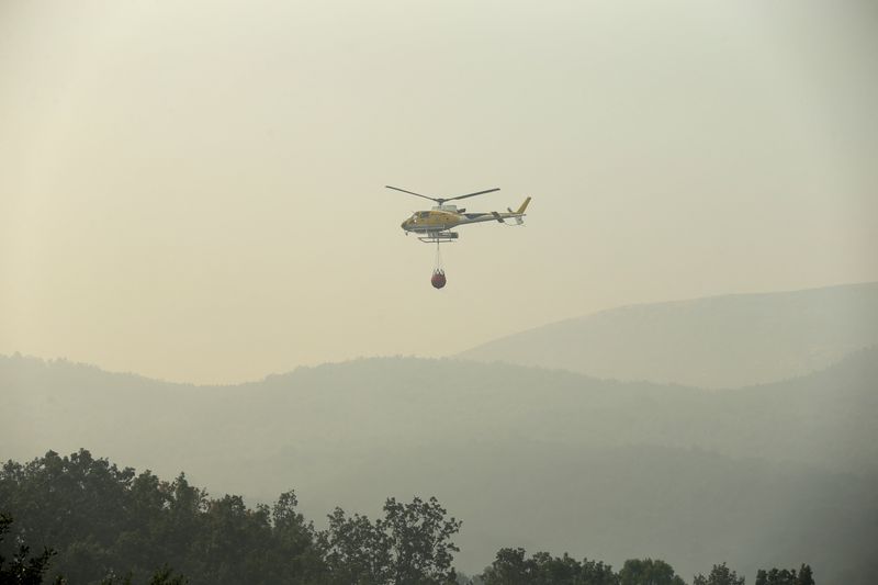 © Reuters. Un helicóptero trabaja para contener un fuego en la reserva natural Garganta de los Infiernos durante una segunda ola de calor en Jerte, España, 17 de julio 2022. REUTERS/Isabel Infantes