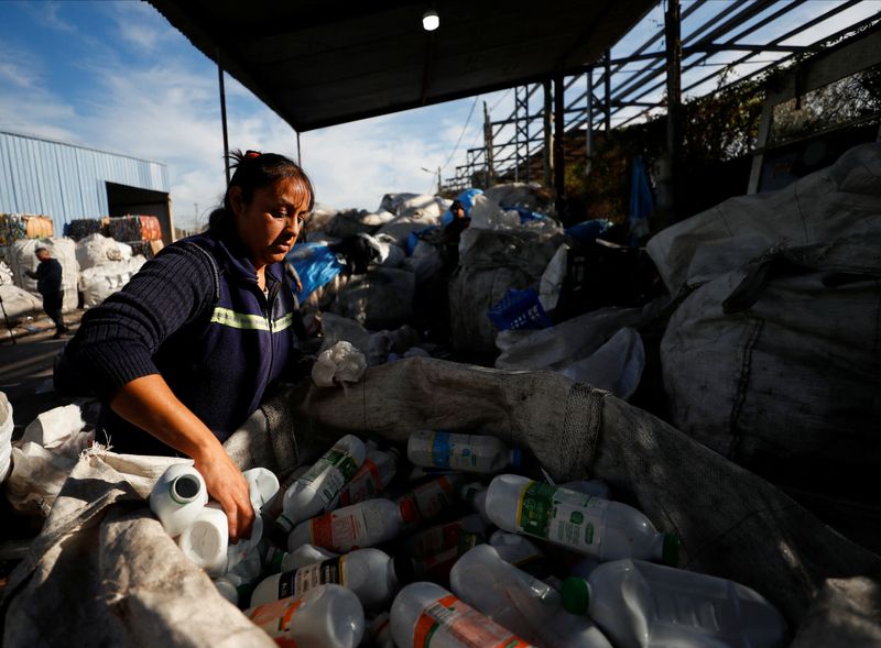 &copy; Reuters. Paola Godoy, que trabalha como catadora de resíduos, coloca garrafas vazias de leite em sacola para serem recicladas em Lomas de Zamora, nos subúrbios de Buenos Aires
08/07/2022 REUTERS/Agustin Marcarian