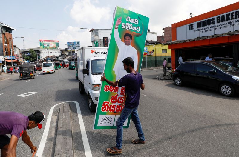 &copy; Reuters. Un partidario de Sajith Premadasa, candidato presidencial de Sri Lanka de la alianza Nuevo Frente Democrático, lleva un cartel suyo cerca de una oficina de campaña, en Colombo, Sri Lanka 13 de noviembre de 2019. REUTERS/Dinuka Liyanawatte/Archivo