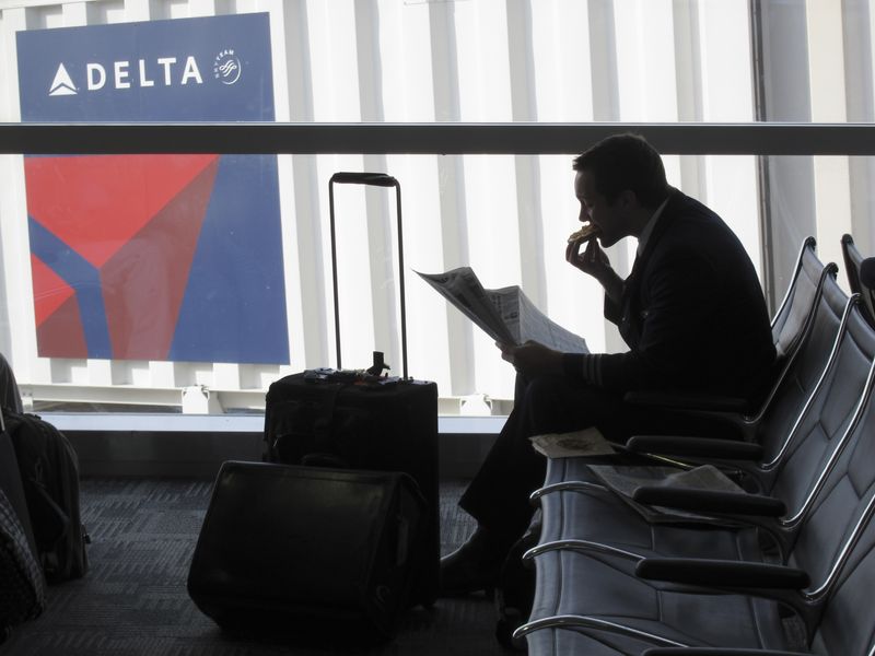&copy; Reuters. FILE PHOTO: A passenger waits for his flight near a Delta Air Lines logo at Detriot Airport November 20, 2010. REUTERS/Sim Wei Yang (UNITED STATES - Tags: TRANSPORT BUSINESS)