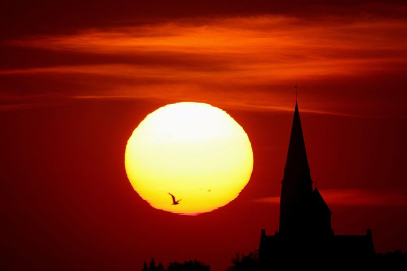 &copy; Reuters. Vista de igreja durante o pôr do sol em Oisy-le-Verger, na França, em meio a onda de  calor que atinge Europa
14/07/2022 REUTERS/Pascal Rossignol 