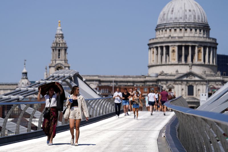 &copy; Reuters. Personas cubriéndose del sol en el Puente del Milenio durante una ola de calor, en Londres, Reino Unido, el 18 de julio de 2022. REUTERS/Maja Smialkowska