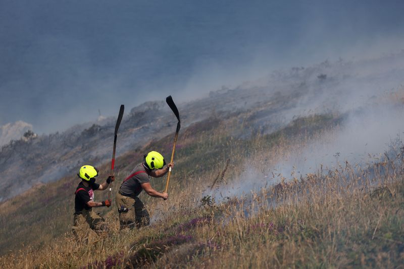 &copy; Reuters. Los bomberos actúan para apagar un incendio de arbustos de tojo, durante una ola de calor cerca de Zennor, Cornualles, Reino Unido, el 19 de julio de 2022. REUTERS/Tom Nicholson