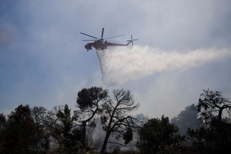 &copy; Reuters. طائرة إطفاء هليكوبتر تلقي مياه على حرائق غابات في باليني بالقرب من أثينا يوم الأربعاء. تصوير: كوستاس بالتاس - رويترز