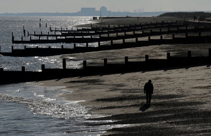 © Reuters. FILE PHOTO: A man walks along the beach along the Suffolk coast as the Sizewell B nuclear power station can be seen on the horizon, near in Southwold, Britain, January 31, 2019.  REUTERS/Russell Boyce/