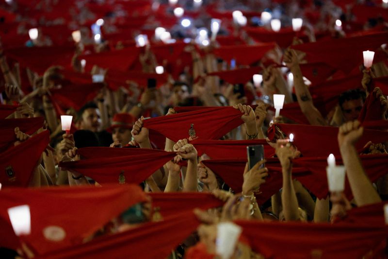 &copy; Reuters. FOTO DE ARCHIVO: Los asistentes sostienen pañuelos rojos y velas durante la ceremonia de clausura de las fiestas de San Fermín después de la medianoche en Pamplona, España, 15 de julio de 2022. REUTERS/Juan Medina
