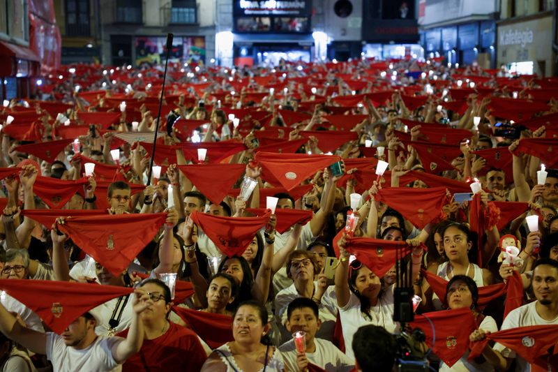 &copy; Reuters. Foliões seguram bandeiras vermelhas e velas durante a cerimônia de encerramento da Festa de San Fermin, em Pamplona, Espanha
15/07/2022 REUTERS/Juan Medina