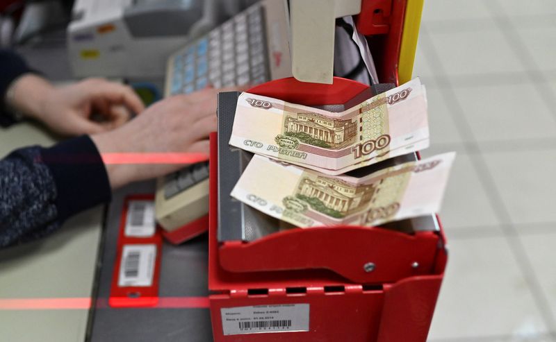 &copy; Reuters. FILE PHOTO: Russian 100-rouble banknotes are placed on a cashier's desk at a supermarket in the Siberian town of Tara in the Omsk region, Russia, December 14, 2021. Picture taken December 14, 2021. REUTERS/Alexey Malgavko