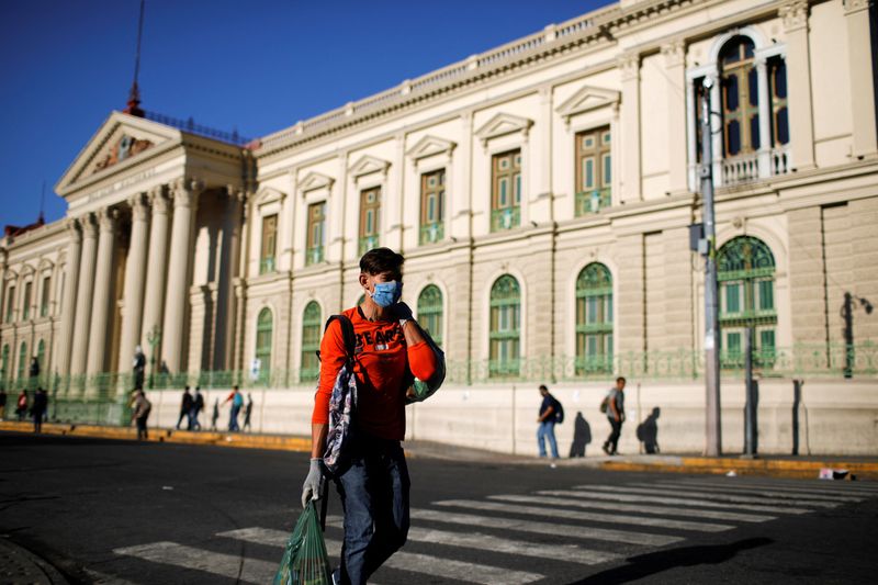 © Reuters. FILE PHOTO: A man walks after buying groceries in front of the National Palace after El Salvador's President Nayib Bukele ordered home quarantine for 30 days throughout the country as the government undertakes steadily stricter measures to prevent a possible spread of the coronavirus disease (COVID-19), in San Salvador, El Salvador March 22, 2020. REUTERS/Jose Cabezas/File Photo