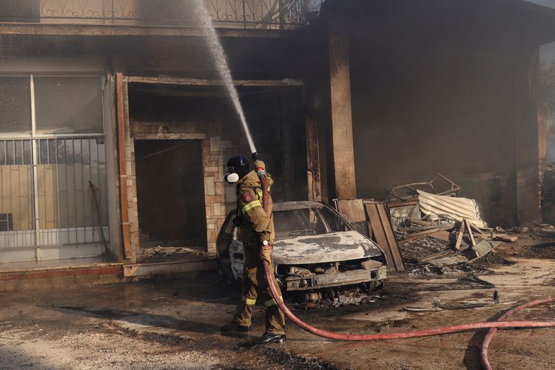 &copy; Reuters. 異例の熱波に見舞われている欧州では、２０日も山火事の消火活動が続いた。科学者などからは気候変動対策強化を求める声が高まっている。写真は７月２０日、ギリシャのアテネ近郊で撮