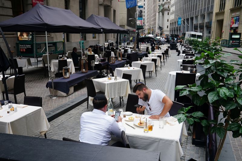 &copy; Reuters. FILE PHOTO: People eat at a mostly empty restaurant with tables on the street, in the financial district during the coronavirus disease (COVID-19) pandemic in the Manhattan borough of New York City, New York, U.S., September 9, 2020.  REUTERS/Carlo Allegr