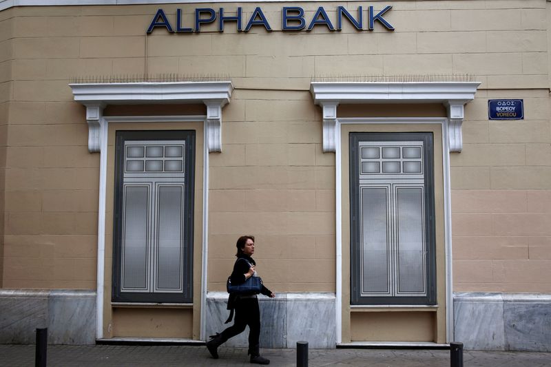 &copy; Reuters. FILE PHOTO: A woman makes her way past the logo of Alpha Bank in Athens March 26, 2014.  REUTERS/Yorgos Karahalis