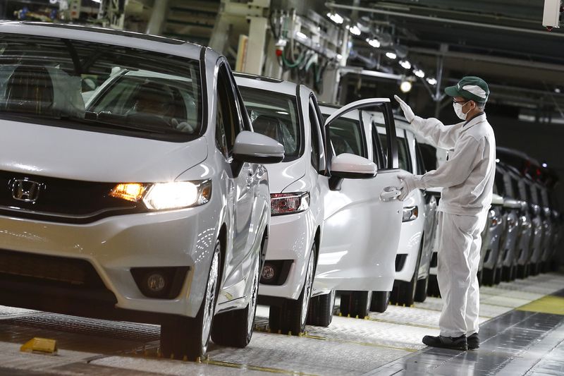 © Reuters. FILE PHOTO: A worker conduct quality checks on Honda Fit vehicles at the Honda Motor Co. plant in Yorii, Saitama prefecture, Japan,  March 8, 2016. REUTERS/Thomas Peter/File Photo