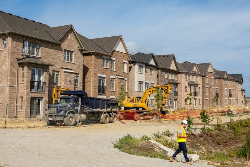 © Reuters. FILE PHOTO: A construction crew walks in front of new homes under construction, on the day Bank of Canada increased its policy rate a full percentage point in Brampton, Ontario, Canada July 13, 2022. REUTERS/Carlos Osorio/File Photo