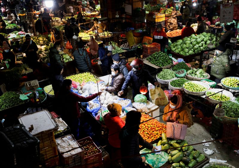 &copy; Reuters. FILE PHOTO: People buy and sell vegetables at a market as Nepal recorded 10,258 new COVID-19 infections on Tuesday, the highest number reported in a single day as the government projected the tally could double by the end of the month as the coronavirus d