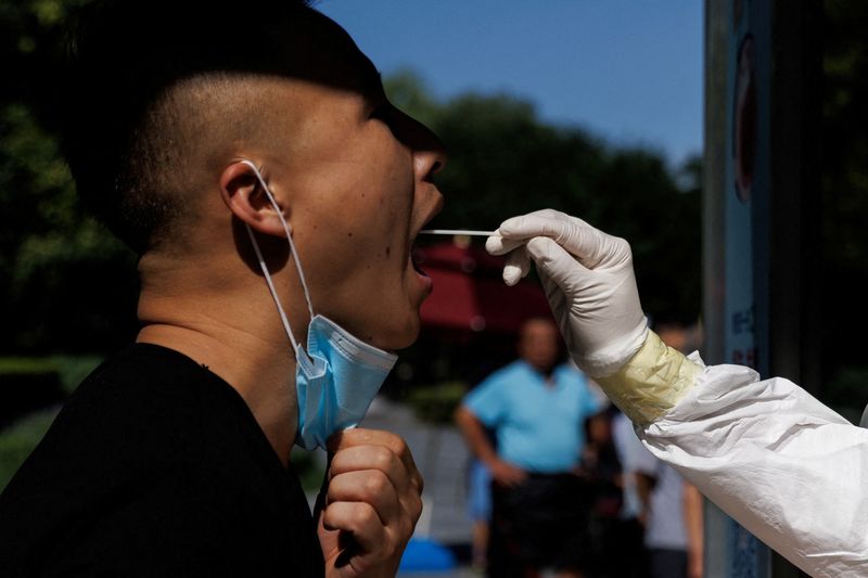 &copy; Reuters. FILE PHOTO: A man gets a swab test at a nucleic acid testing station, following a coronavirus disease (COVID-19) outbreak, in Beijing, China, July 14, 2022. REUTERS/Thomas Peter/