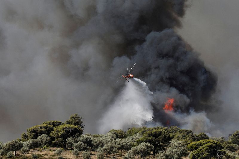 &copy; Reuters. FILE PHOTO: A firefighting helicopter makes a water drop as a wildfire burns in the Pikermi suburb of Athens, Greece, July 20, 2022. REUTERS/Louiza Vradi