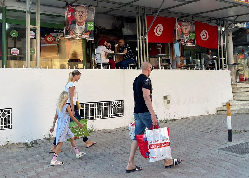&copy; Reuters. FILE PHOTO: People walk past a cafe decorated with Tunisian flags and pictures of Tunisia's President Kais Saied, ahead of an upcoming referendum on a new constitution, in Tunis, Tunisia July 15, 2022. REUTERS/Jihed Abidellaoui