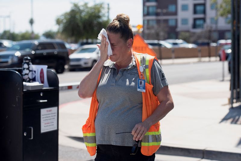&copy; Reuters. Vangie Jacobo wipes her face with a wet rag while working outside in 106 degree heat in Phoenix, Arizona, U.S. July 23, 2022.  REUTERS/Rebecca Noble