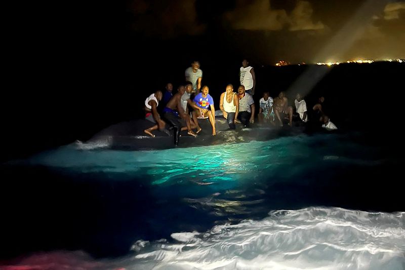 © Reuters. ناجون كانوا على متن قارب مهاجرين انقلب قبالة جزيرة نيو بروفيدانس في جزر الباهاما يوم السبت. صورة لرويترز من قوة دفاع جزر الباهاما الملكية. يحظر إعادة بيعها أو وضعها في أرشيف.