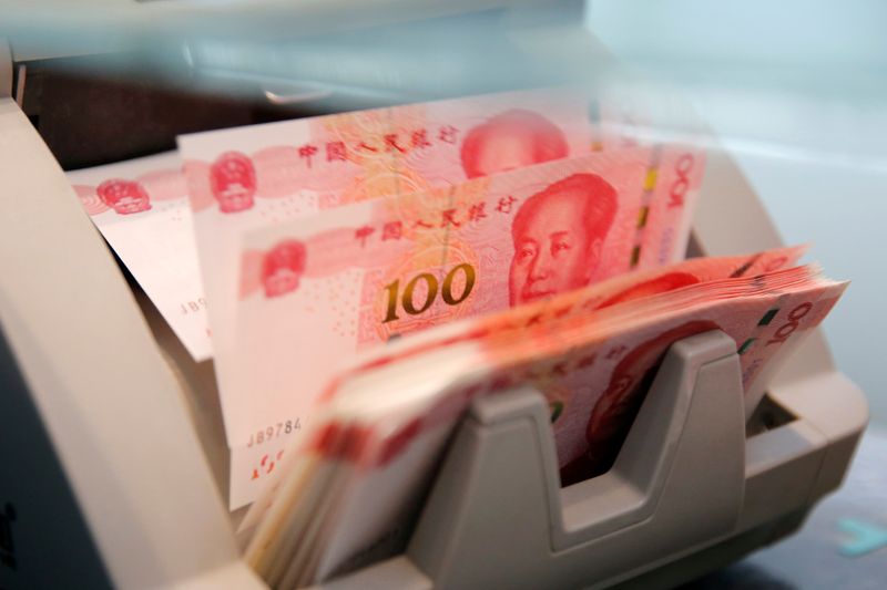 &copy; Reuters. FOTO DE ARCHIVO: Billetes chinos de 100 yuanes en una máquina contadora mientras un empleado los cuenta en una sucursal de un banco comercial en Beijing, China