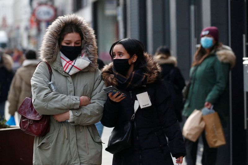 &copy; Reuters. FILE PHOTO: People, wearing protective face masks, walk on a street in Brussels, amid the rise of the coronavirus disease (COVID-19) cases due to the Omicron variant in Belgium, January 21, 2022. REUTERS/ Johanna Geron/
