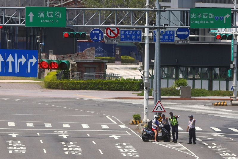 &copy; Reuters. Une femme sur une moto est invitée à se mettre à l'abri à Taipei pendant l'exercice de raid aérien appelé Wan An, un exercice annuel de 30 minutes. Taïwan a mené lundi un exercice de préparation à une frappe aérienne alors que le scénario d'un