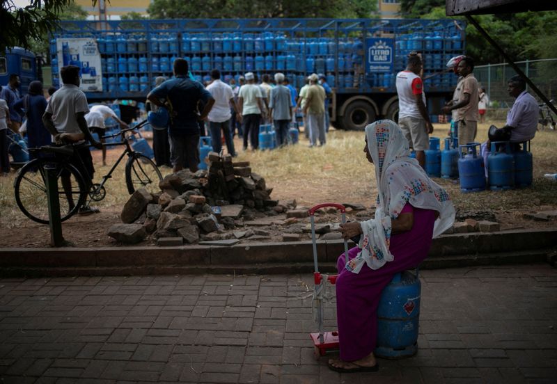 &copy; Reuters. FILE PHOTO: A woman sits on an empty domestic cooking gas cylinder at a distribution centre, amid the country's economic crisis, in Colombo, Sri Lanka, July 23, 2022. REUTERS/Adnan Abidi