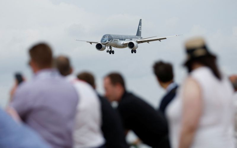 &copy; Reuters. IMAGEN DE ARCHIVO: Los asistentes observan un avión Embraer 190 durante una exhibición en el Salón Aeronáutico Internacional de Farnborough, en Farnborough, Gran Bretaña